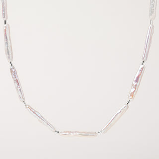 Collana con perle d'acqua dolce allungate e dettagli in Argento su sfondo neutro