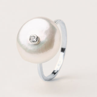 Anello dal design aperto con una perla d'acqua dolce da una parte e uno zircone dall'altra.