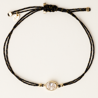 Bracciale a filo regolabile con elemento organico in argento dorato e zircone.