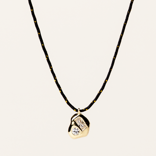 Collana regolabile con filo e pendente sagomato in argento dorato con zircone.
