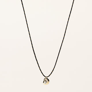 Collana regolabile con filo e pendente sagomato in argento dorato con zircone.