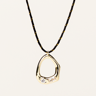 Collana a filo regolabile con pendente organico dorato e zirconi incastonati.