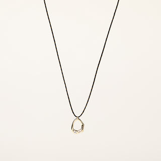 Collana a filo regolabile con pendente organico dorato e zirconi incastonati.