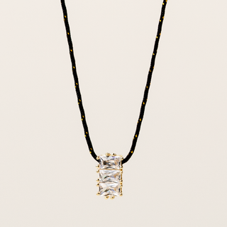 Collana a filo regolabile con pendente dorato e zirconi luminosi incastonati.