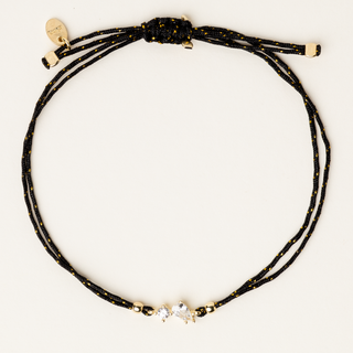 Bracciale a filo con castone dorato e zirconi a goccia e tondo centrali.