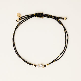 Bracciale a filo con castone dorato e zirconi a goccia e tondo centrali.