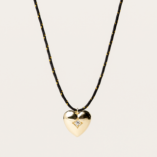 Collana a filo regolabile con pendente sagomato a cuore e zircone centrale.